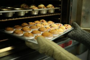 Cupcakes being taken from oven