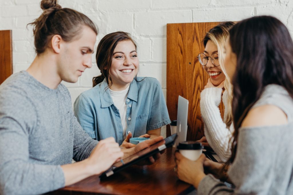 Group of smiling students sitting at a table together