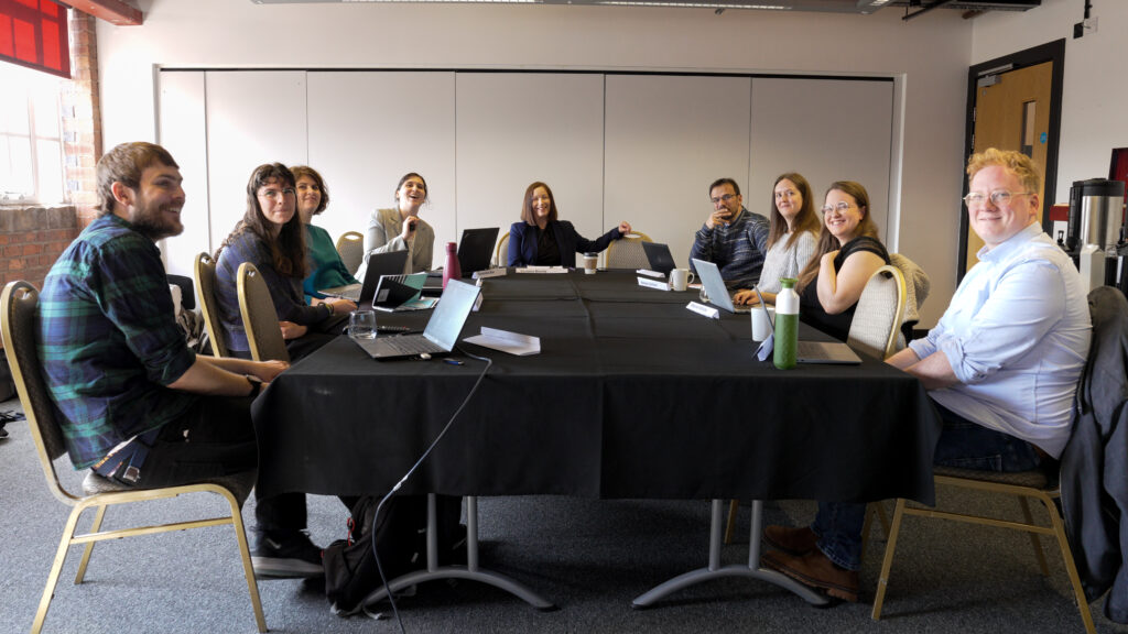 Photo of the Data Impact Fellows and UK Data Service seated around a conference table.