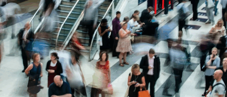 Blurred people walking around a station