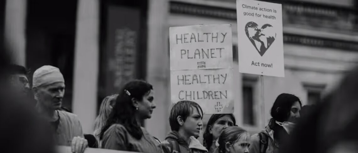 People in a line holding climate and health activism signs